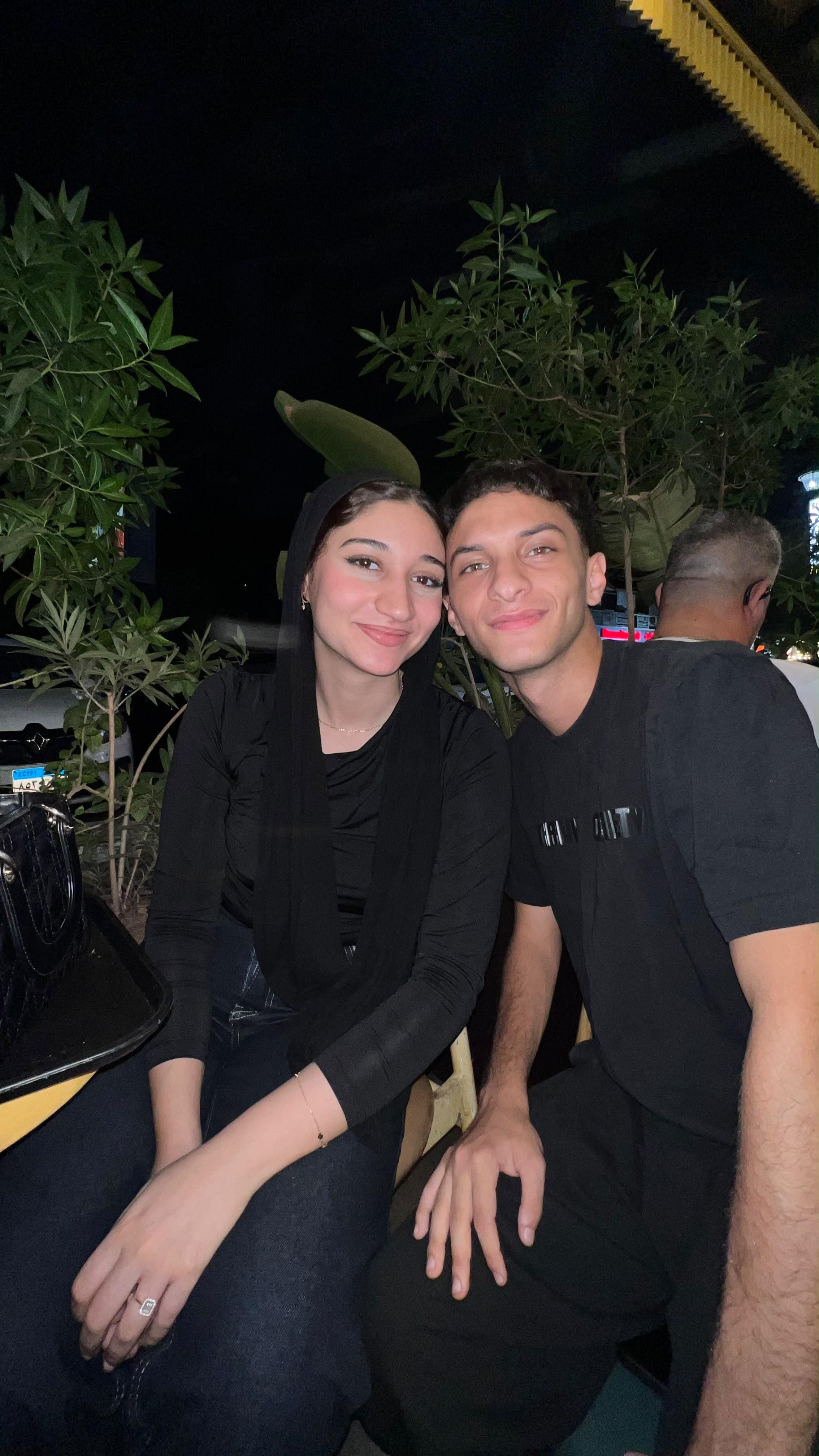 Wed and 3amour sitting close together among leafy plants at night