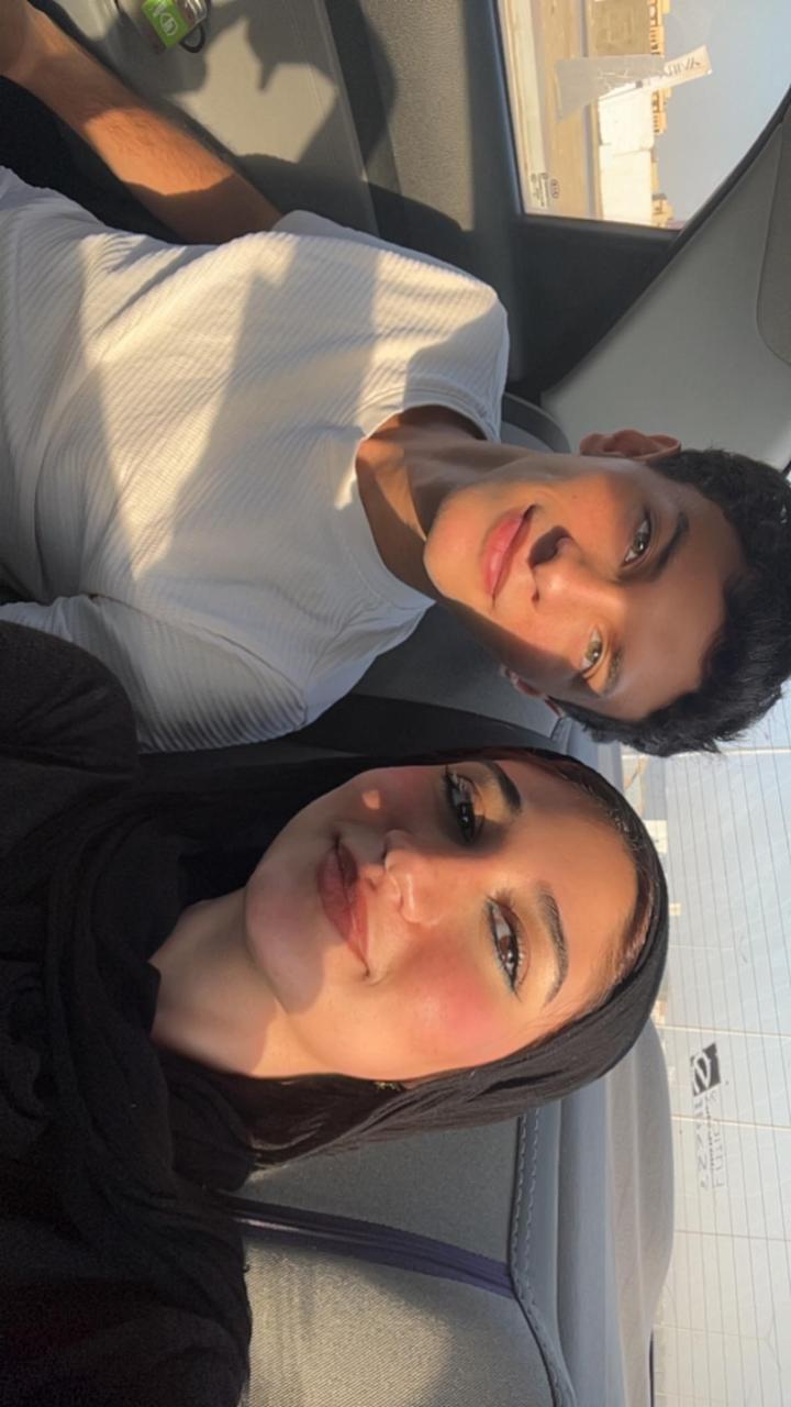 Wed and 3amour together in the car, with warm sunlight across their faces